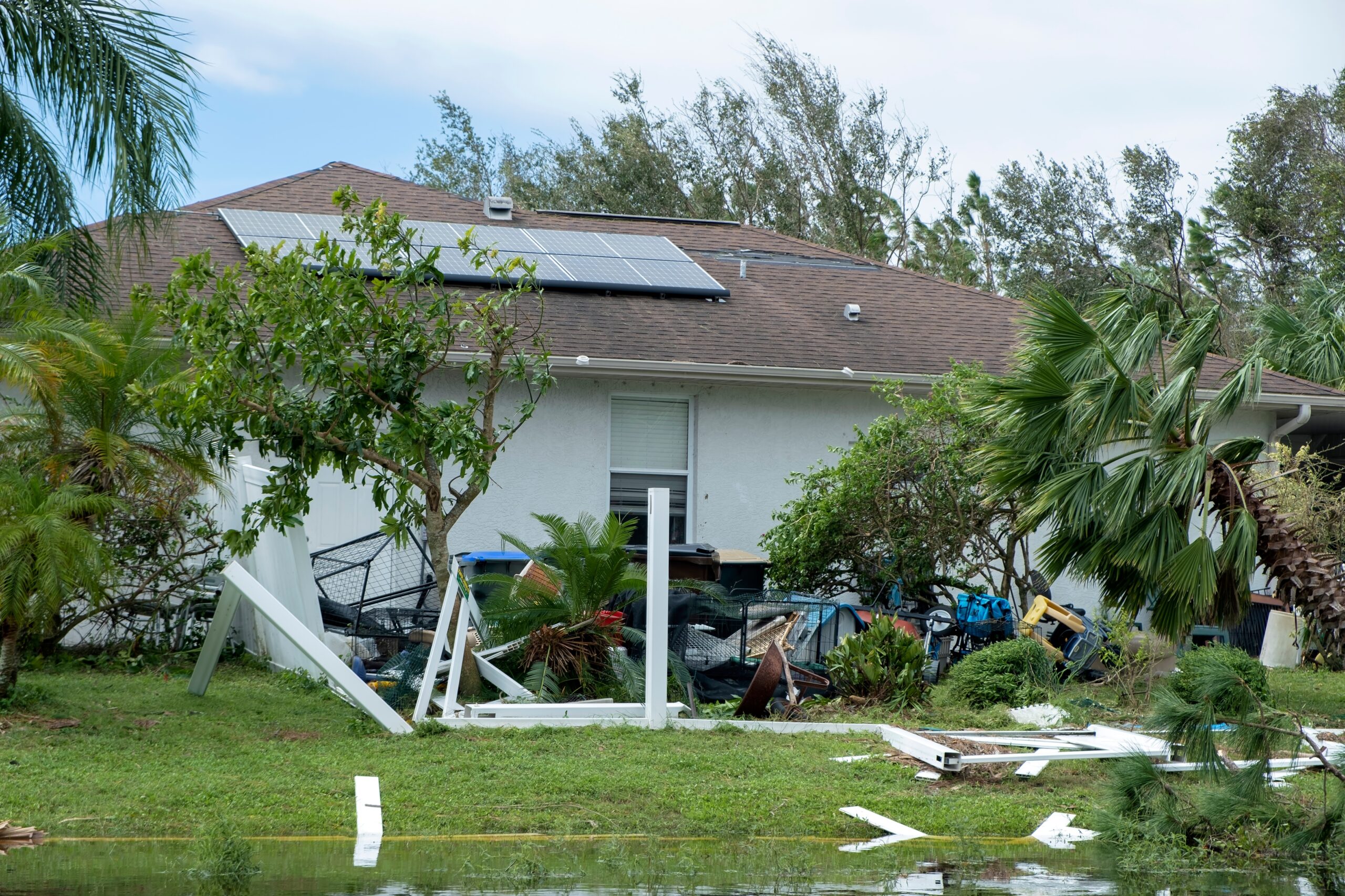 White,Plastic,Backyard,Fence,Damaged,After,Hurricane,Winds,In,Florida. Storm Debris Removal in Dallas and Houston