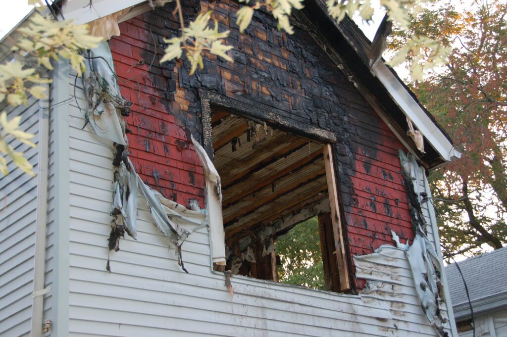 Fire,Damaged,Home,With,Melted,Siding,And,Broken,Glassfire,Damaged. Fire Damage Restoration and Smoke Removal